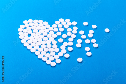 Heart of pills on a blue background.