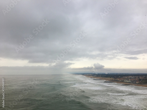 View of a shore, agitated ocean and cloudy sky