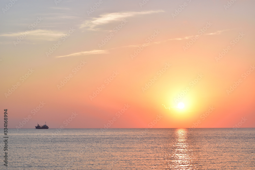 Sunset over the sea and cargo ship