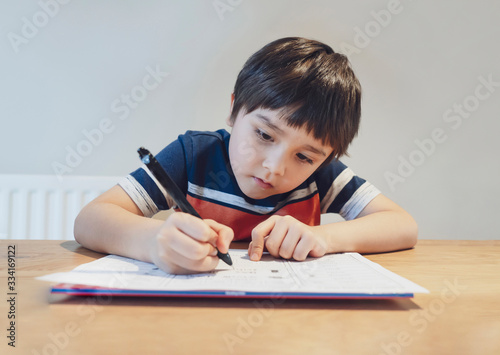 Kid in Self isolation doing his mathematics homework while school off,Child learning math at home during covid lock down,Home schooling and concept of COVID-19 pandemic infection. Social Distancing