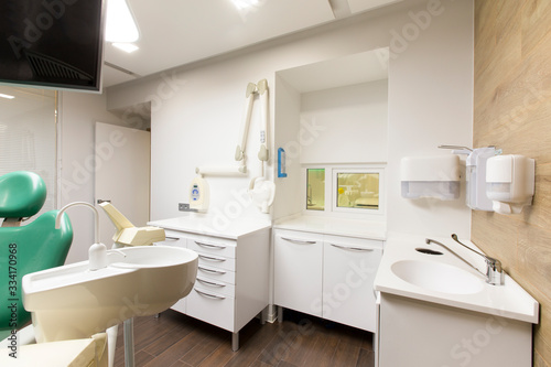 Sink, soap and sanitizer for dentist in modern hospital room