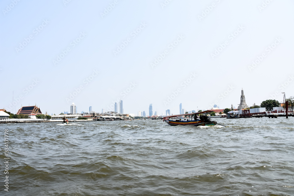 On the Chao Phraya River in Bangkok with some skyscrapers and landmarks in the background