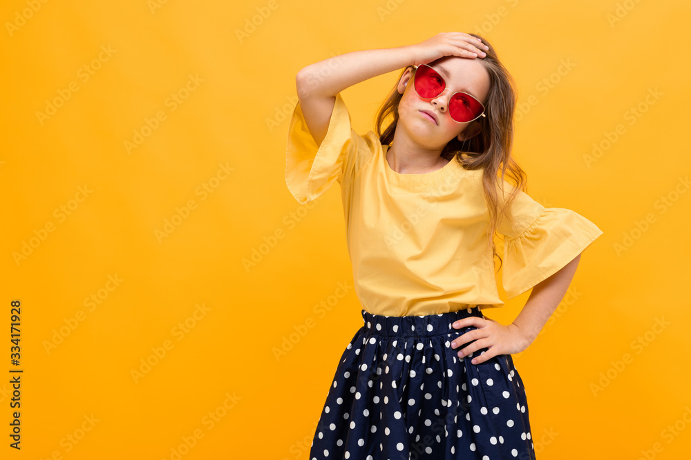 stylish young girl posing isolated on a yellow studio background stylish young girl posing isolated on a yellow studio background