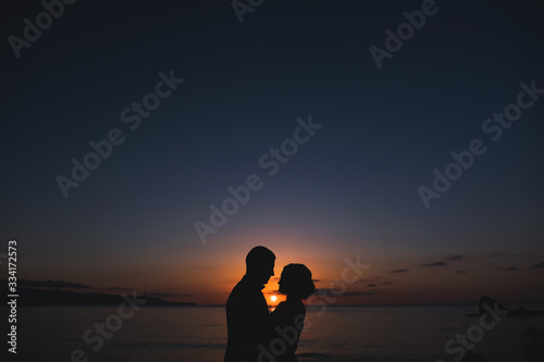 Silhouettes of lovely couple man and woman In beutiful Nature sunset. Couple love concept.