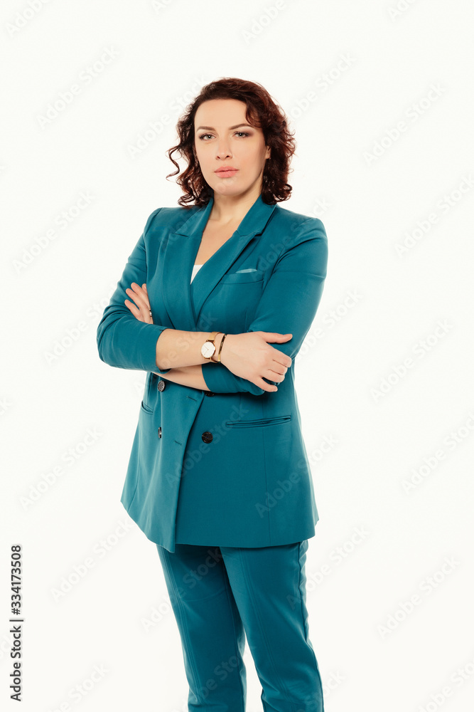 Portrait of serious attractive businesswoman in blue suit posing while standing with arms crossed and looking at camera isolated over white background.