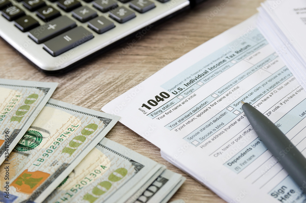 tax forms 1040, calculator, dollars and pen. tax forms 1040, calculator, dollars and pen.
