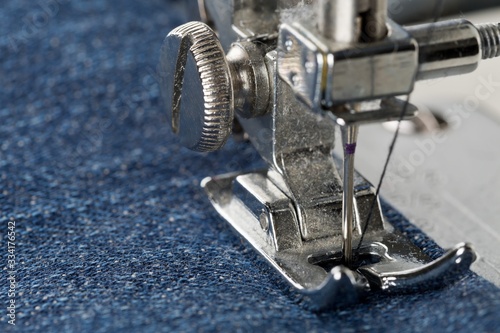 Fotografia, Obraz Blue jeans denim sewed on sewing machine close up - jeans fashion mending or rep