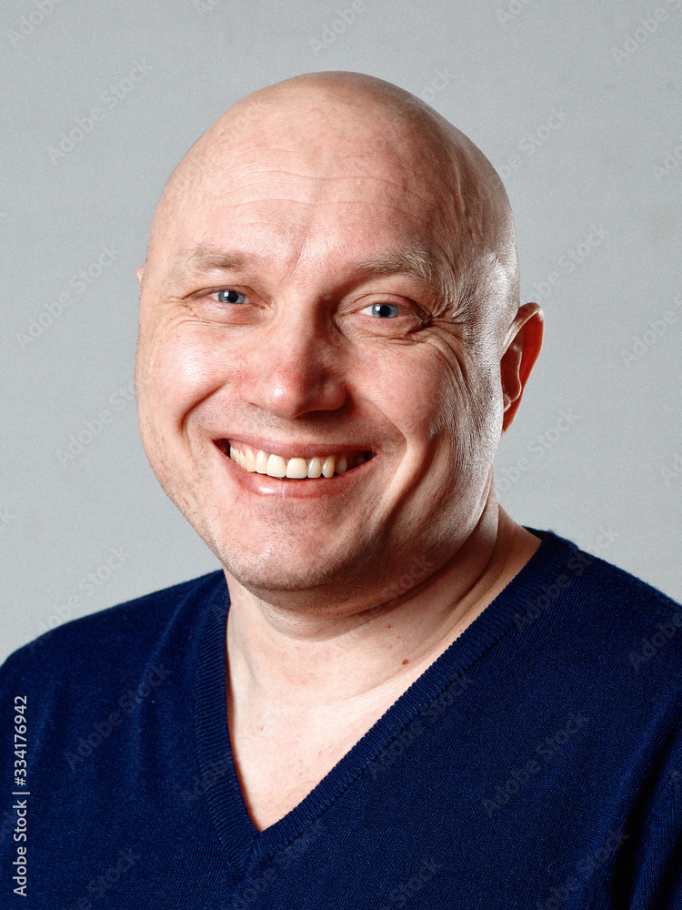 Portrait of a bald cheerful man on a gray background Portrait of a bald cheerful man on a gray background