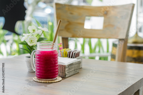 Fresh dragon fruit juice is served in a unique jar and bamboo straw.