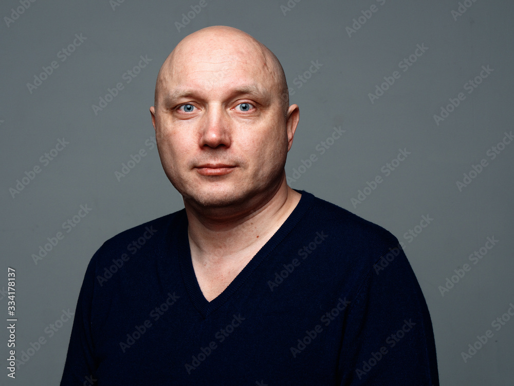 Portrait of a bald cheerful man on a gray background Portrait of a bald cheerful man on a gray background