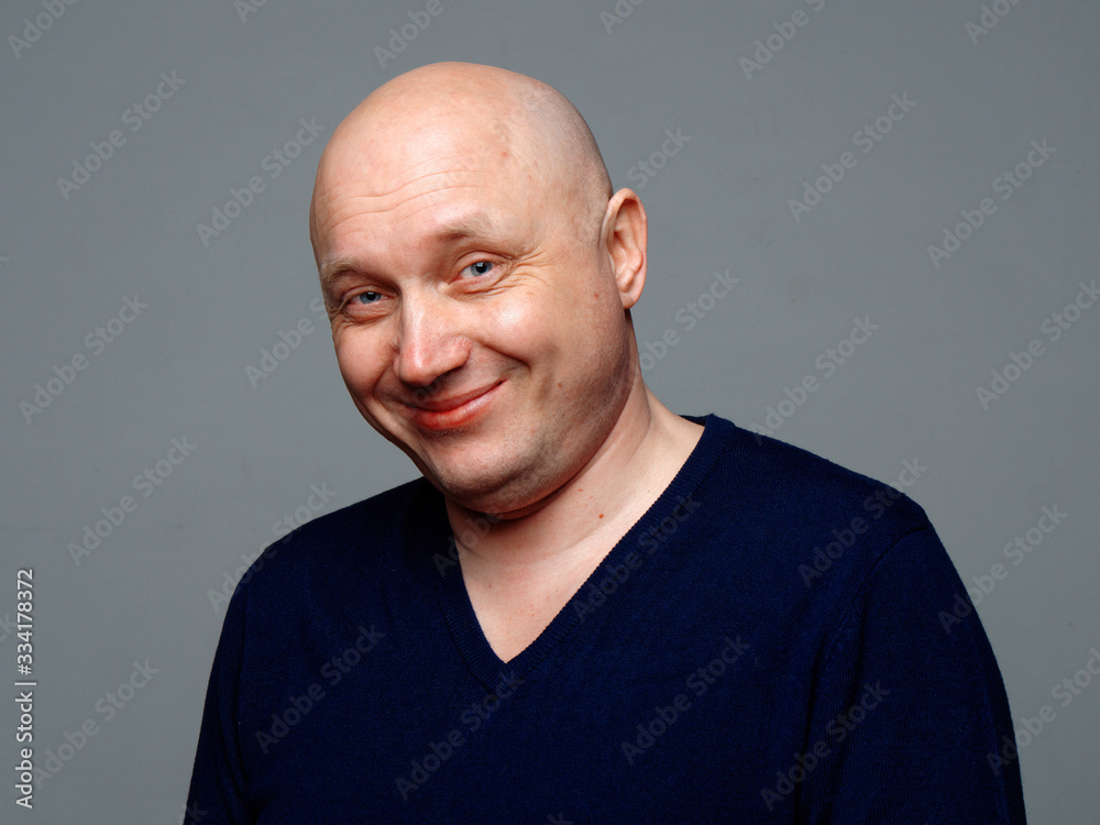 Portrait of a bald cheerful man on a gray background Portrait of a bald cheerful man on a gray background