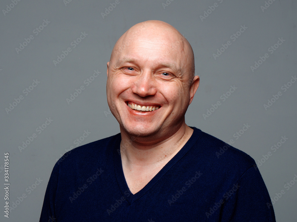 Portrait of a bald cheerful man on a gray background Portrait of a bald cheerful man on a gray background