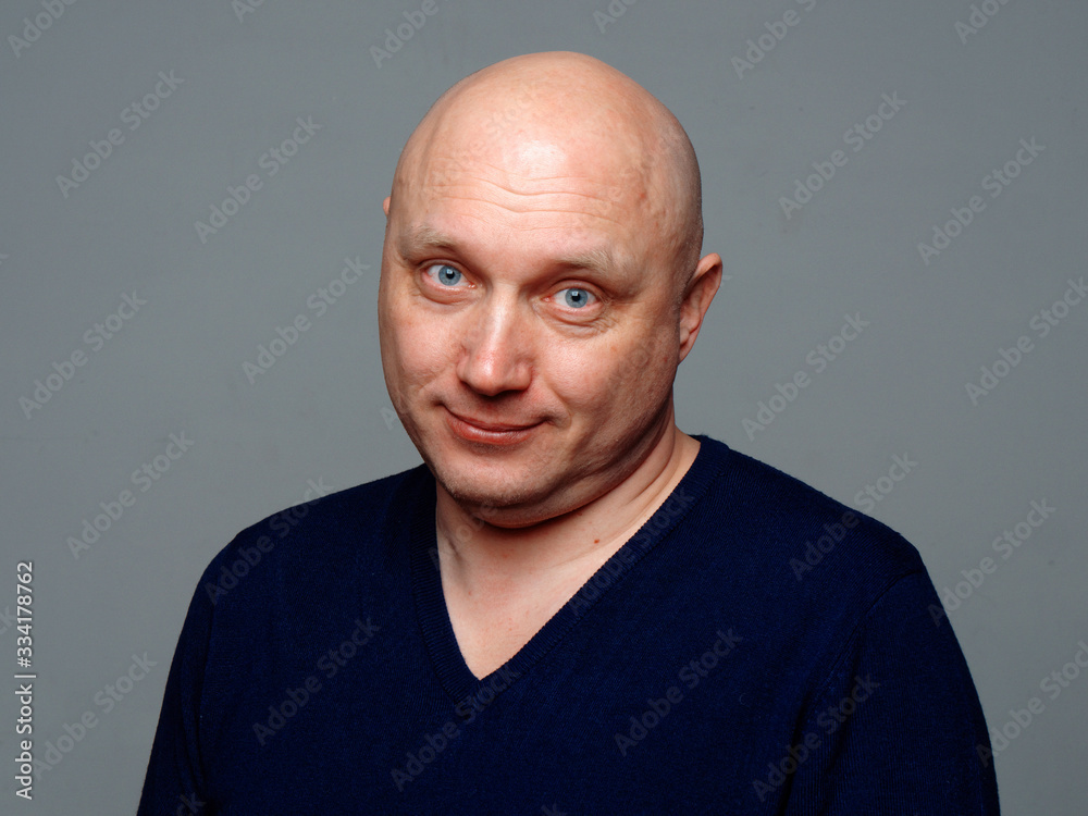 Portrait of a bald cheerful man on a gray background Portrait of a bald cheerful man on a gray background