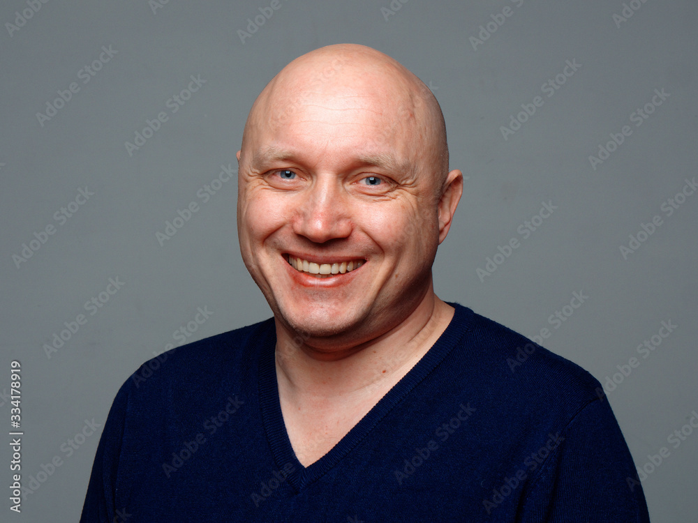 Portrait of a bald cheerful man on a gray background Portrait of a bald cheerful man on a gray background