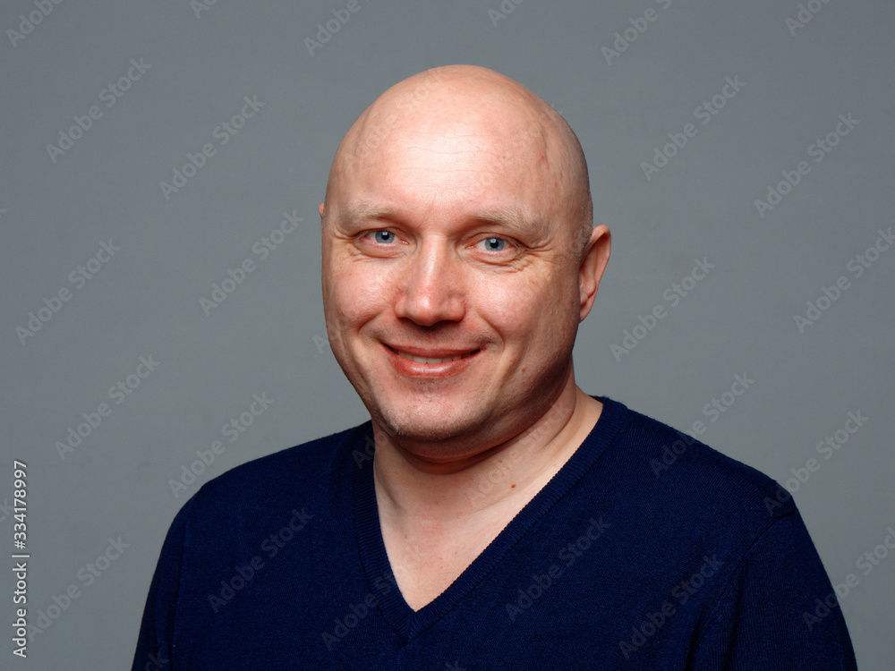 Portrait of a bald cheerful man on a gray background Portrait of a bald cheerful man on a gray background