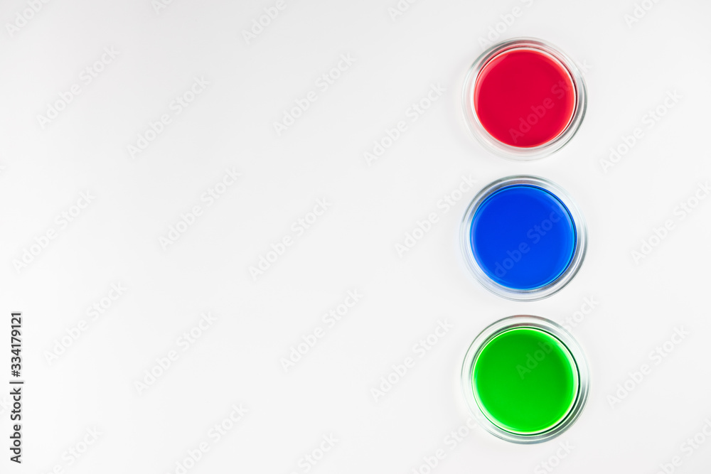 three cups of petri dishes with colored liquid three cups of petri dishes with colored liquid