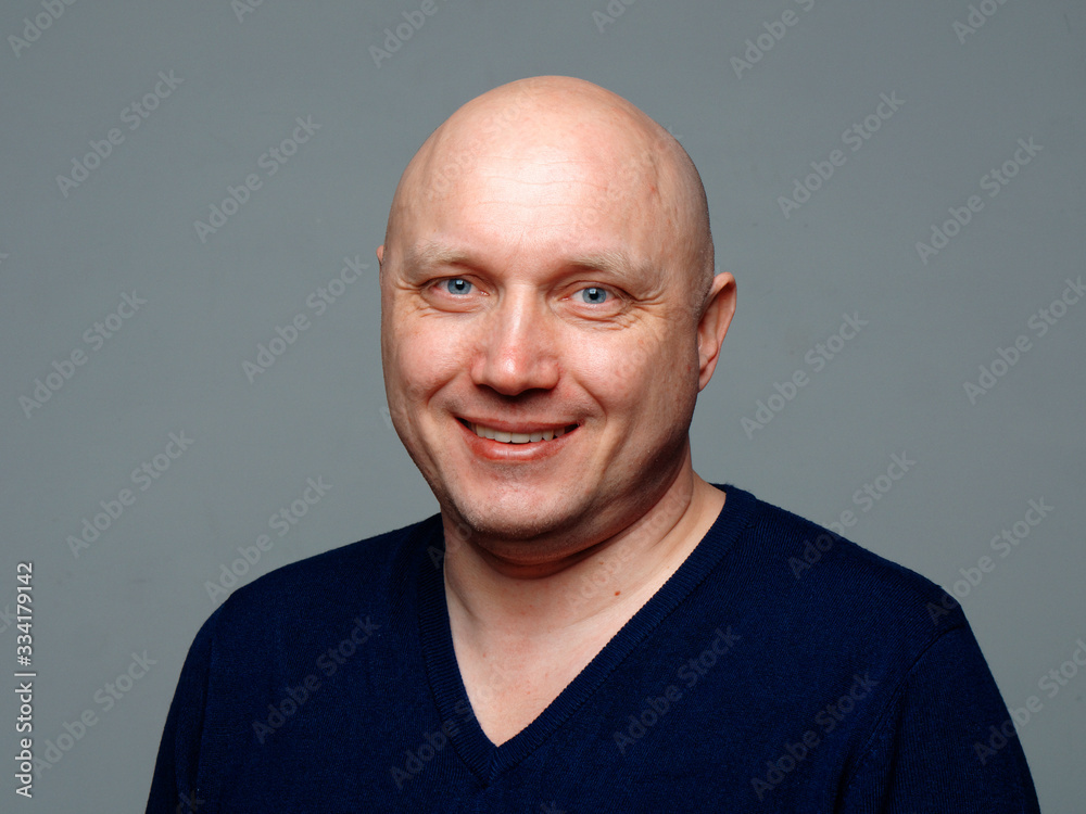 Portrait of a bald cheerful man on a gray background Portrait of a bald cheerful man on a gray background
