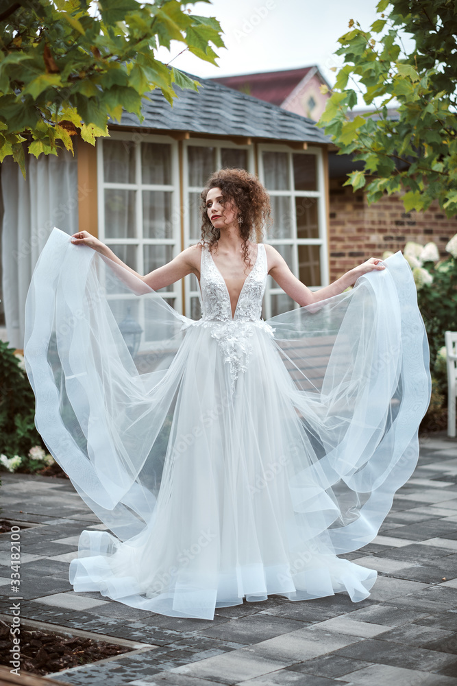 Young bride wearing wedding dress and posing outside Young bride wearing wedding dress and posing outside
