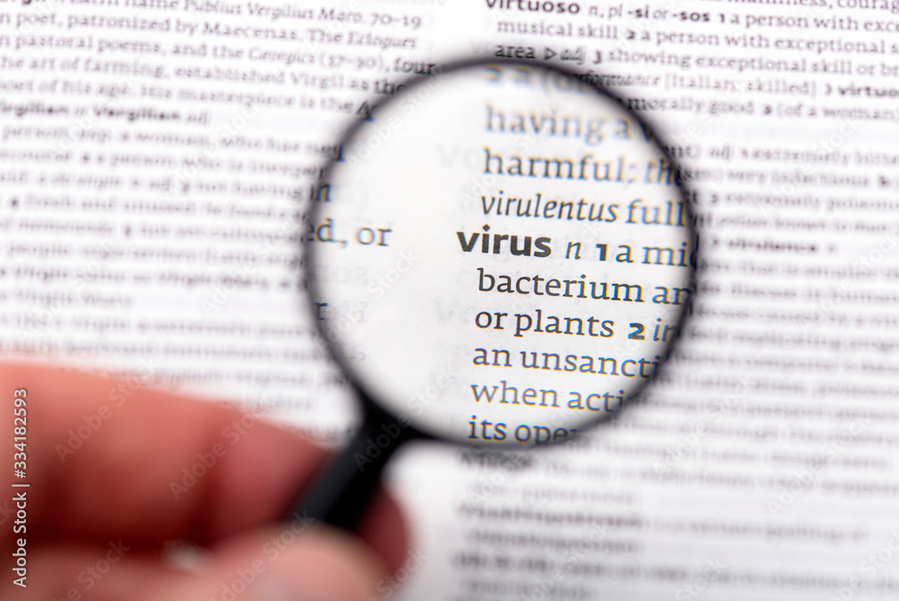 magnifying glass on Page of Book with definition of word virus in dictionary magnifying glass on Page of Book with definition of word virus in dictionary