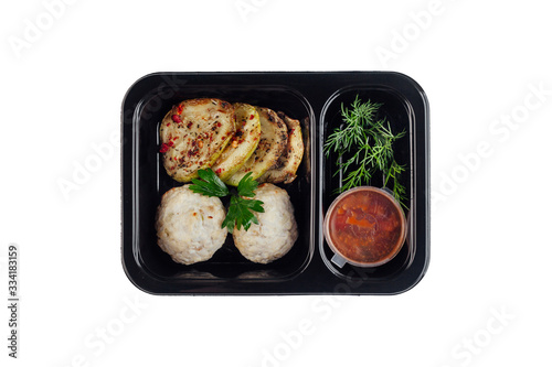 Healthy lunch at workplace. Take away meals in black containers with cutlery on gray table