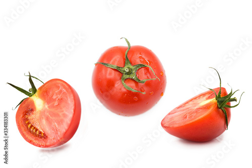 ripe fresh organic tomato and two halves of a tomato in the drops of dew isolated on a white background	