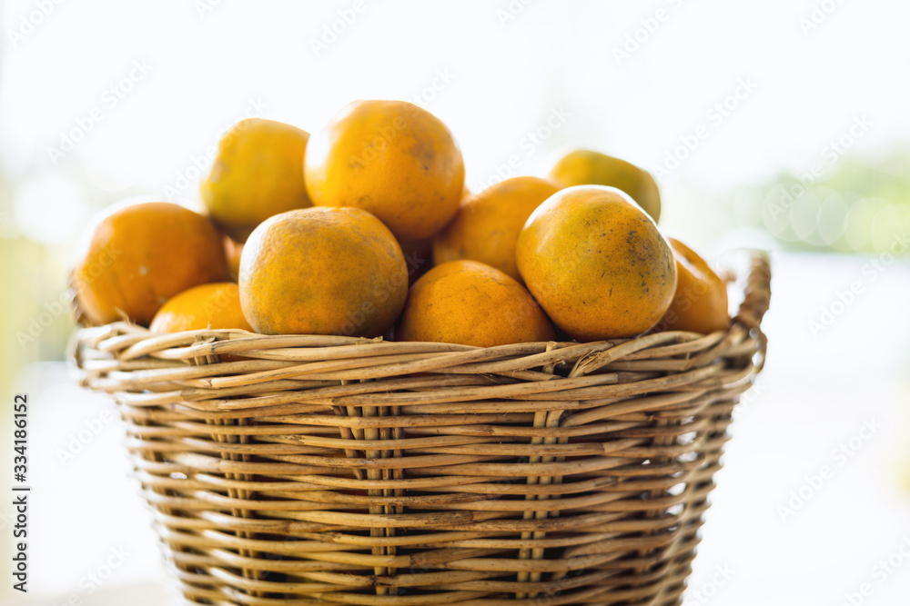Orange in the wicker basket against blurred outdoor background for fruit and eating concept Orange in the wicker basket against blurred outdoor background for fruit and eating concept