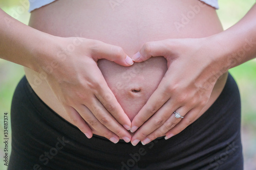 Wallpaper Mural Woman holding her hands in a heart shape on her pregnant belly. Torontodigital.ca
