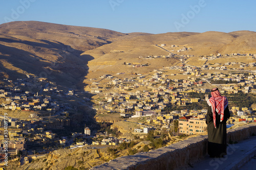 Bédouin avec un chèche contemplant la ville moderne de Pétra, Jordanie photo