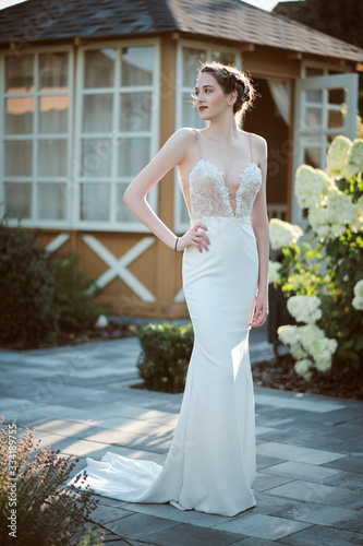 Young bride wearing wedding dress and posing outside