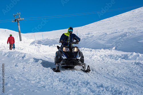 Snowmobile ride in spring on the mountainside in bright daylight