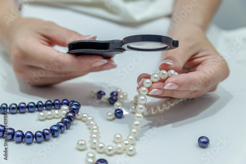 through the magnifier checks the quality of the pearls