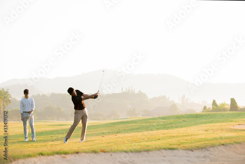 Asian man golfer playing golf with friend at golf course