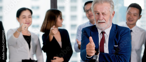 Successful Business man in suit thumb up with team standing on background