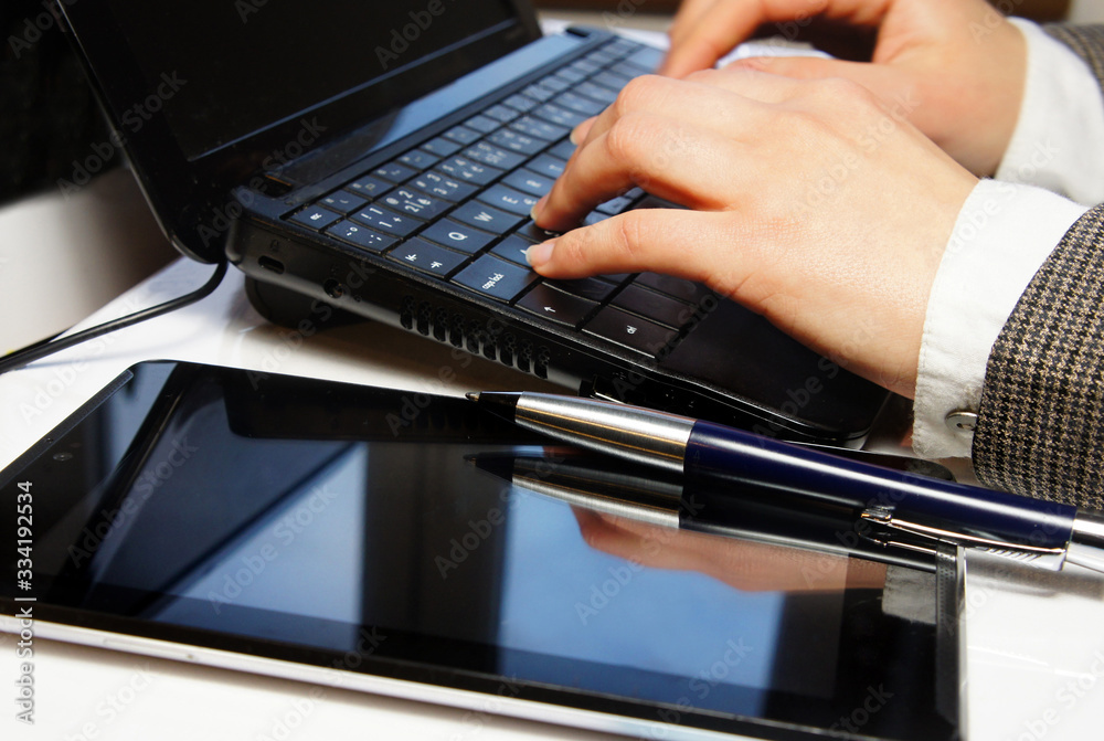 Home office table with laptop and female hands Home office table with laptop and female hands