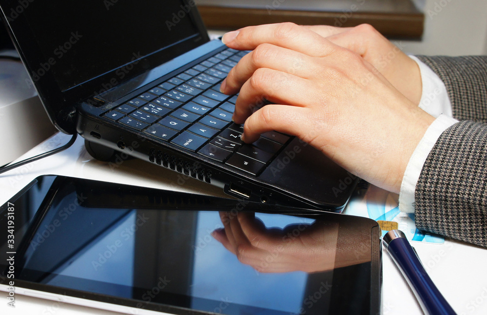 Home office table with laptop and female hands Home office table with laptop and female hands