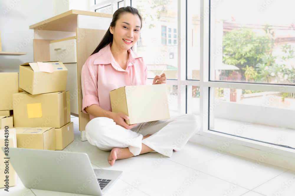 Portrait of beautiful Asian woman packing a parcel boxes close up. E-Commerce and online shopping concept. Portrait of beautiful Asian woman packing a parcel boxes close up. E-Commerce and online shopping concept.