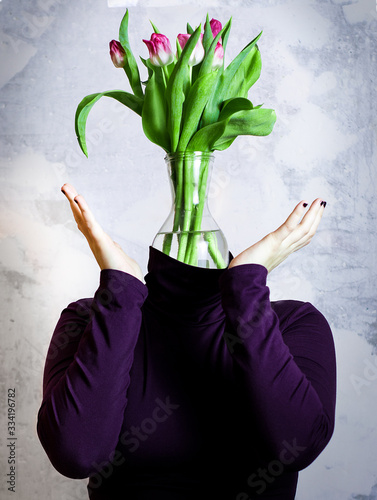 Portrait of very confused unrecognizable woman. She has vase with a bouquet of tulips instead of her head