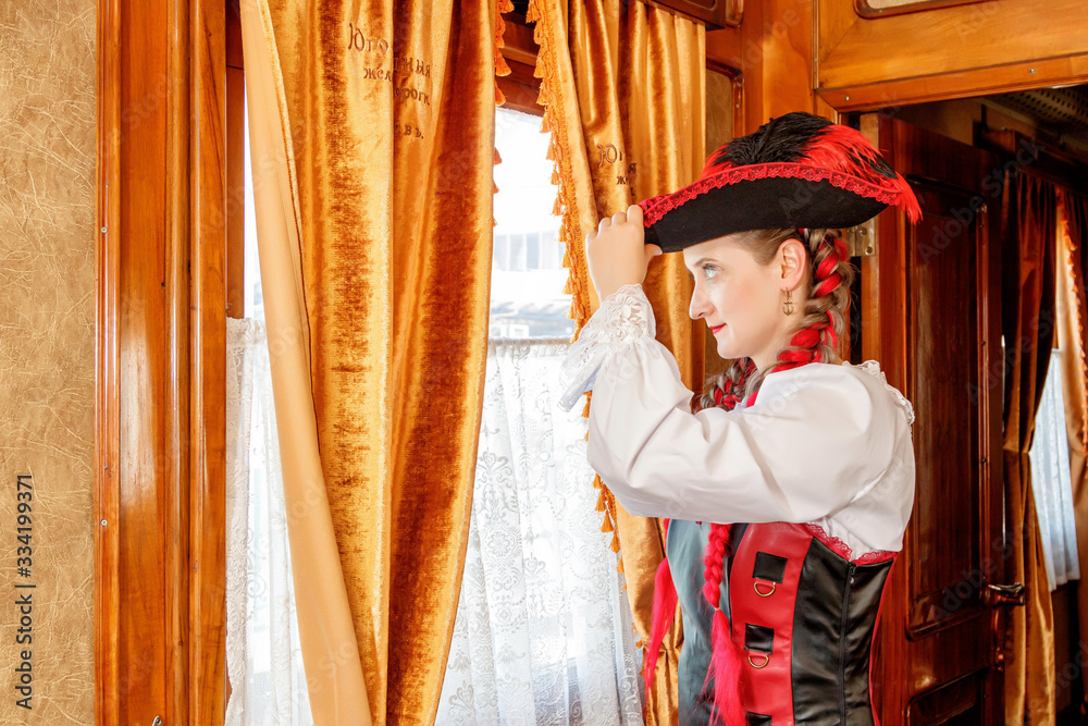 beautiful girl in steampunk costume in an old train carriage