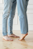 girl in light jeans stretches on toes to a guy in light jeans