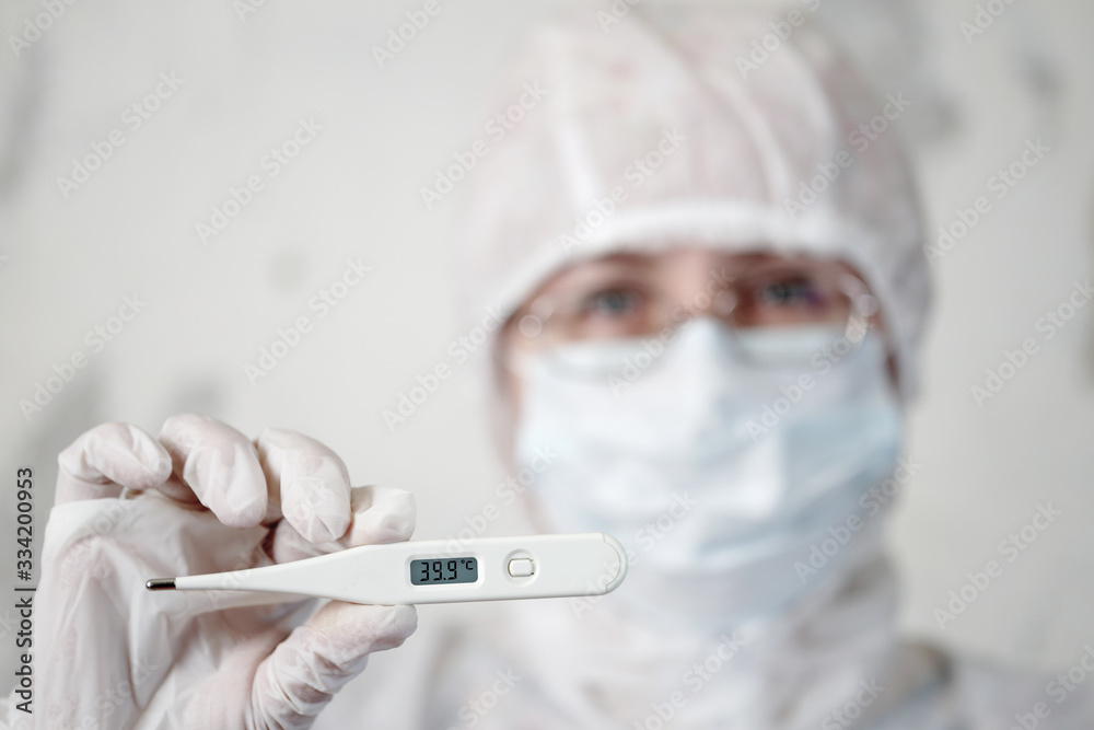 female doctor in medical mask on face holds thermometer with hand female doctor in medical mask on face holds thermometer with hand