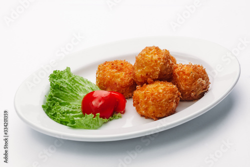 cheese balls on a white plate and a white background