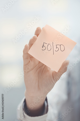 Fifty-fifty text on adhesive note