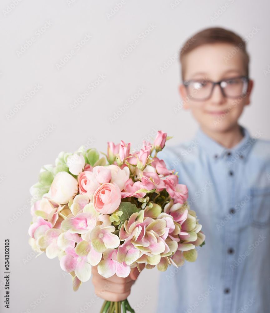 Child boy with bouquet of flowers. Mother's Day Greeting Card. Happy mothers day frame background. Spring card template. Happy Birthday or Valentine. Women's Day. Copy space. Child gives bouquet