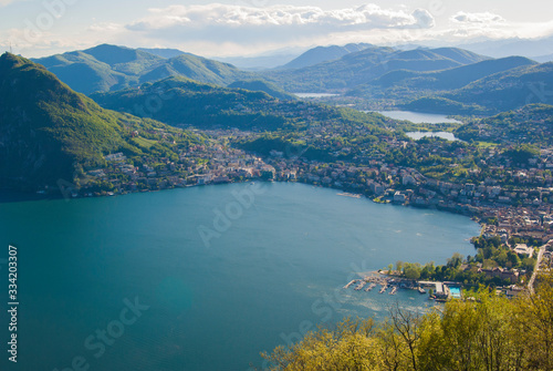 Top view of the city of Lugano  Switzerland from the height of Mount Monte Bre. Beautiful mountain scenery on a sunny summer day. View of Lake Lugano and the Alpine mountains.