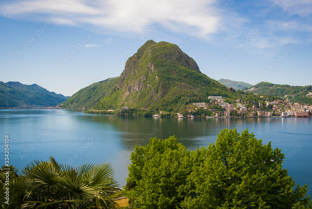 View of Lake Lugano and Mount San Salvatore on a sunny summer day. Alpine mountain scenery in the city of Lugano, Switzerland. 