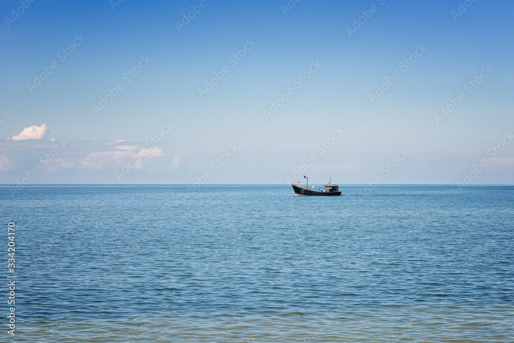 Fishing boat flows near the shore of the Baltic Sea.