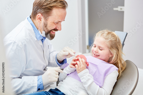 Pediatric dentist tells child the planned treatment