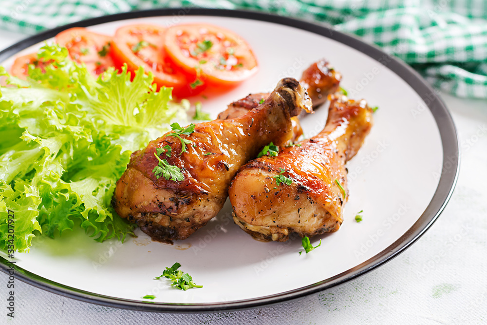 Grilled chicken legs with spices and fresh vegetables. Baked drumsticks.