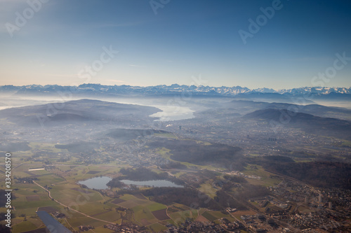 Aerial view of Zurich and Lake Zurich. In the background the Swiss Alps are visible. No clouds and a blue sky add to the scenic view.