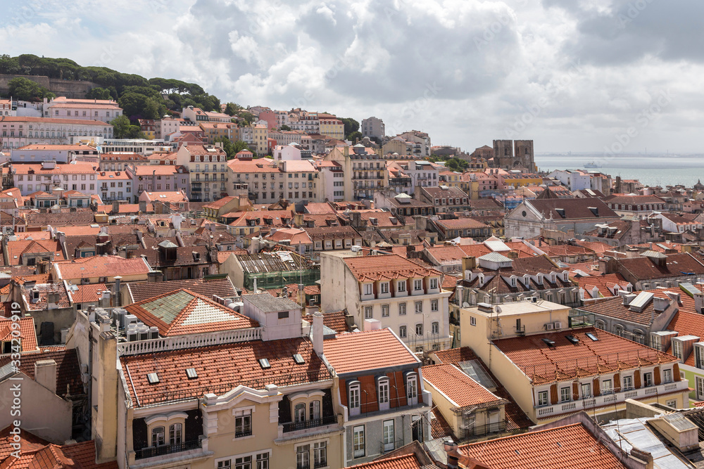 Top view on Lisbon, tiled roofs of houses and the Tagus River. Lisbon, Portugal. Summer sunny day